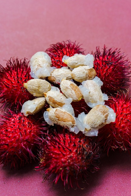 Des graines de rambutan sur un fond rouge Le rambutan est un fruit tropical