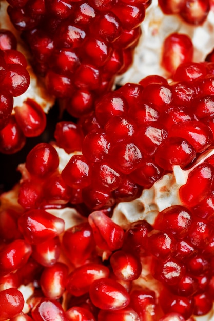 Graines rouges mûres et juteuses de gros plan de fruits de grenade fraîche.