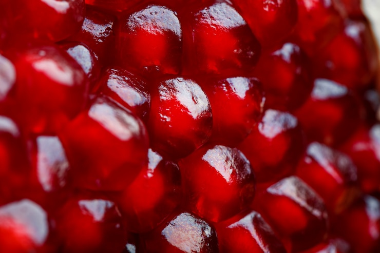 Photo graines rouges mûres et juteuses de gros plan de fruits de grenade fraîche.