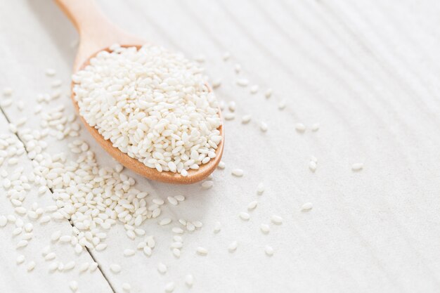 graines de sésame blanc sur une cuillère en bois