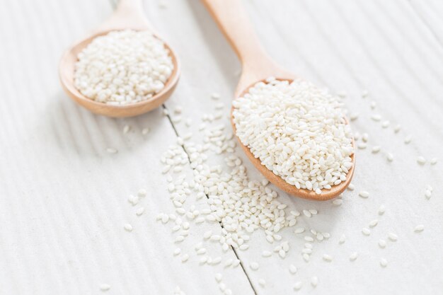 graines de sésame blanc sur une cuillère en bois