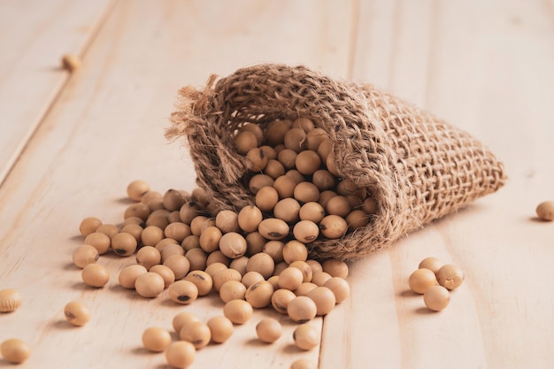 Graines de soja en sac sur table avec espace de copie. Le soja est un aliment diététique sain riche en protéines, faible en gras et en acides aminés essentiels.