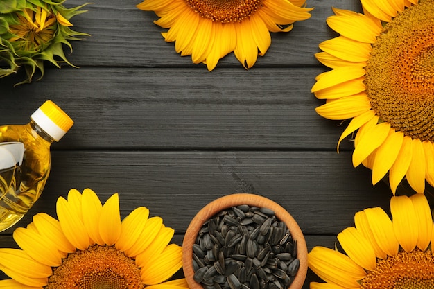 Photo graines de tournesol et bouteille d'huile sur table en bois noir.