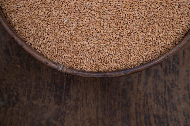 Grains de blé dans un bol sur une vue de dessus de fond en bois