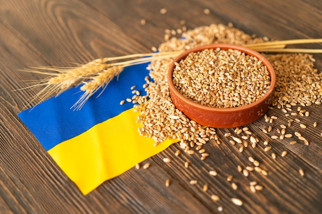 Grains de blé avec drapeau ukrainien jaune et bleu sur fond de bois