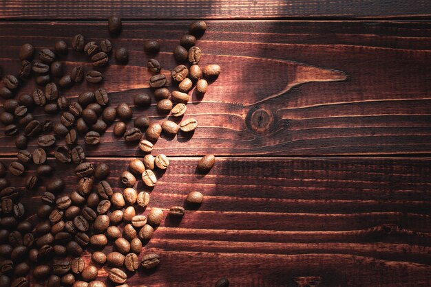 Grains de café Arabica sur le fond en bois Produits alimentaires naturels populaires