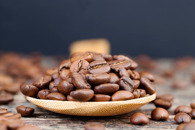 Grains de café aromatiques dans une cuillère en bois