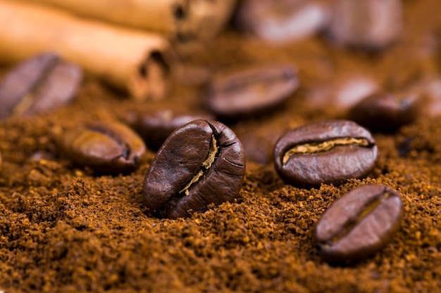 Grains de café aromatiques pendant la préparation de la boisson, grains de café entiers délicieux et parfumés à la surface, gros plan