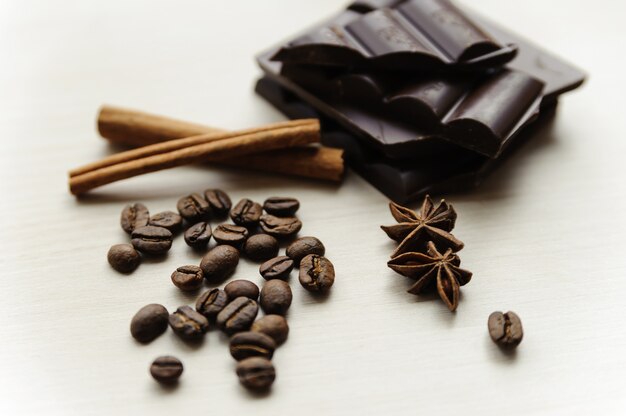 Photo grains de café avec des bâtons de cannelle et du chocolat