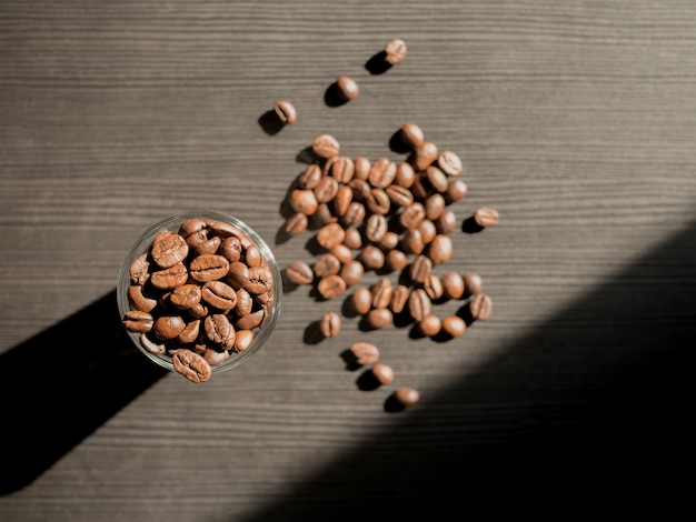 Grains de café avec bouteille en verre et lumière du soleil