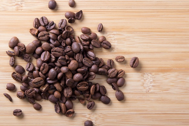 des grains de café bruns sur un fond en bois