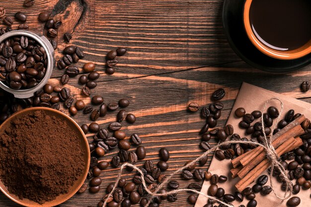 Grains de café, café moulu et tasse de café infusé sur une table en bois rustique, vue d'en haut avec un espace pour le texte. Nature morte. Maquette. Mise à plat