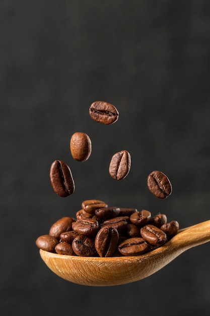 Grains de café chute macro sur fond gris