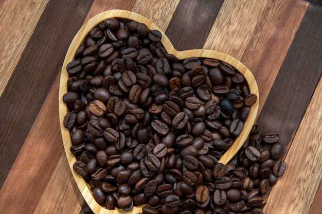 Grains de café dans un plateau en forme de cœur représentant l'amour du café