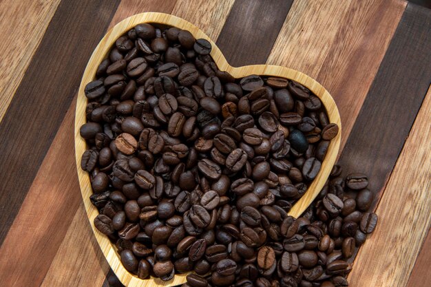 Grains de café dans un plateau en forme de cœur représentant l'amour du café