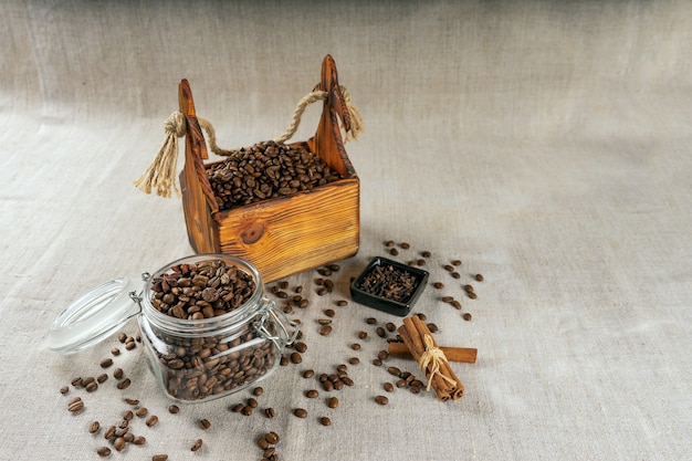 Grains de café dans un récipient, cannelle, muscade et clous de girofle.