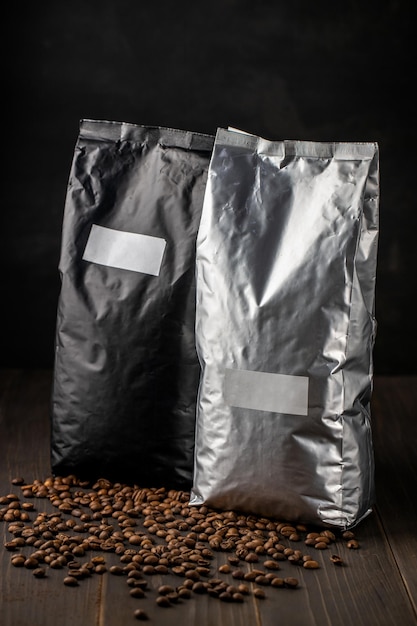 Grains de café dans les sacs d'emballage sur fond sombre