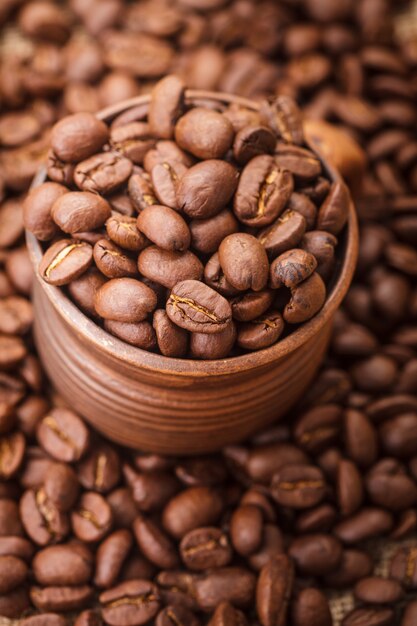 Grains de café dans la tasse d'argile se bouchent