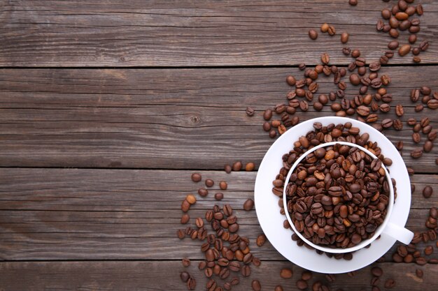 Grains de café dans une tasse en bois gris