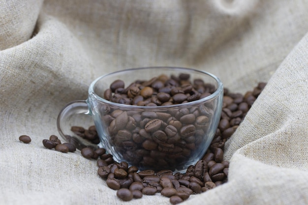 Grains de café dans la tasse sur un sac