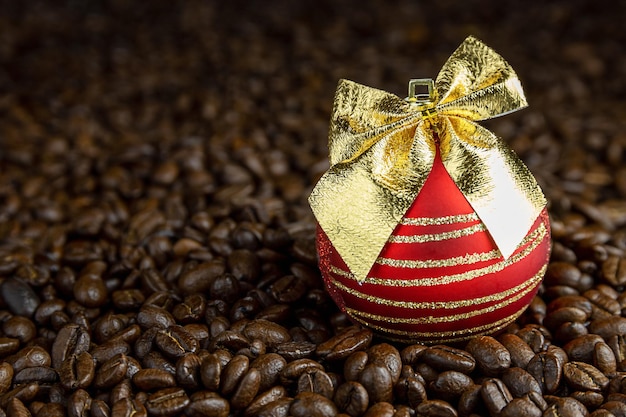 Grains de café décorés d'une boule de verre de Noël rouge avec un arc doré