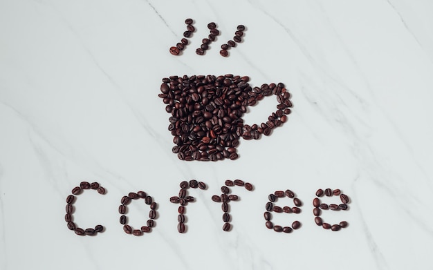 Grains de café épars et tasse à café expresso sur fond de marbre