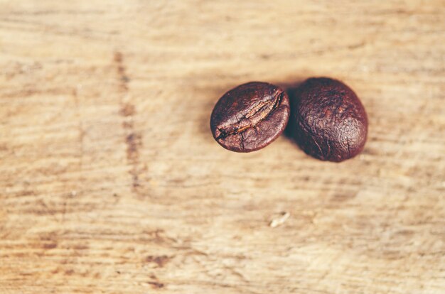 Grains de café sur fond en bois, café arabica, image de filtre vintage