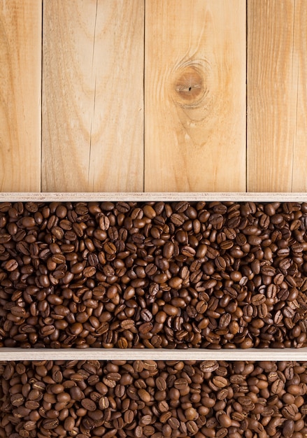 Grains de café en fond de boîte de planche de bois, vue de dessus