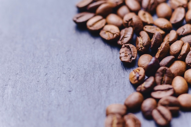 Grains de café sur fond de pierre noire avec une place vide