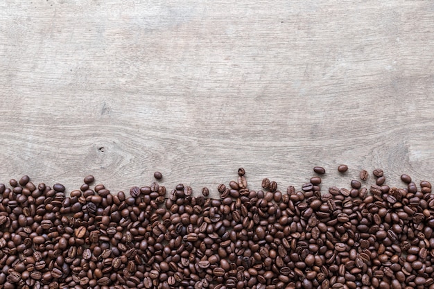 Grains de café sur fond de plancher en bois. vue de dessus