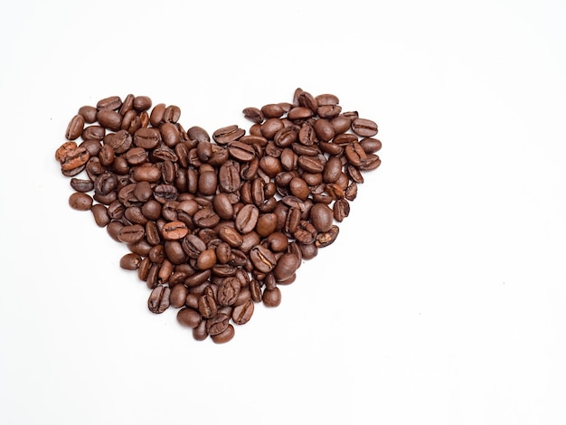 Grains de café en forme de coeur sur blanc