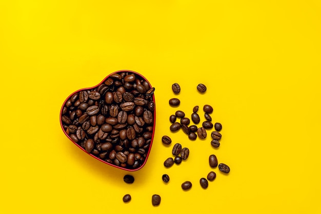 Grains de café en forme de coeur sur jaune