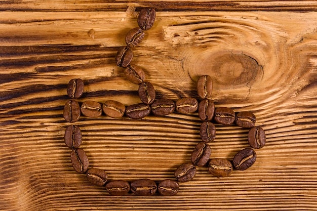 Grains de café en forme de tasse sur une table en bois rustique. Vue de dessus