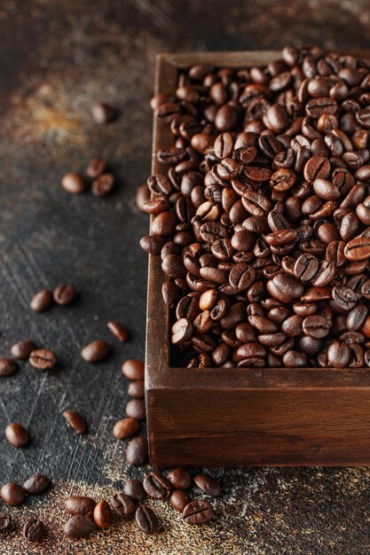 Grains de café fraîchement torréfiés dans une boîte en bois