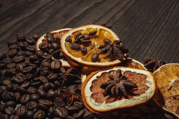 Grains de café à l'orange séchée et à la cannelle sur un fond en bois