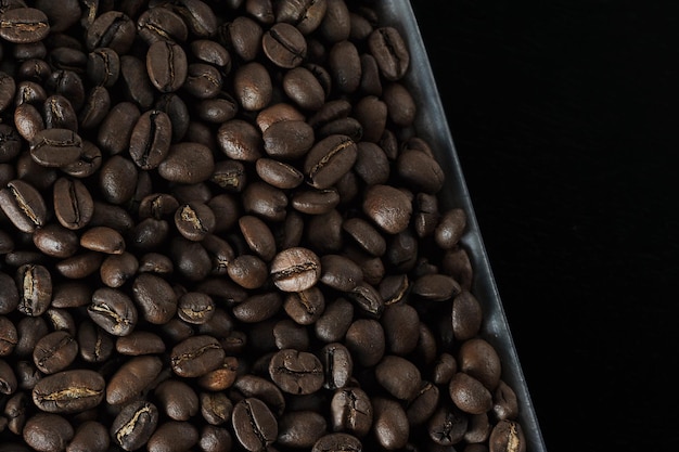Grains de café - photo en gros plan de grains fraîchement torréfiés - fond de café - vue de dessus à plat