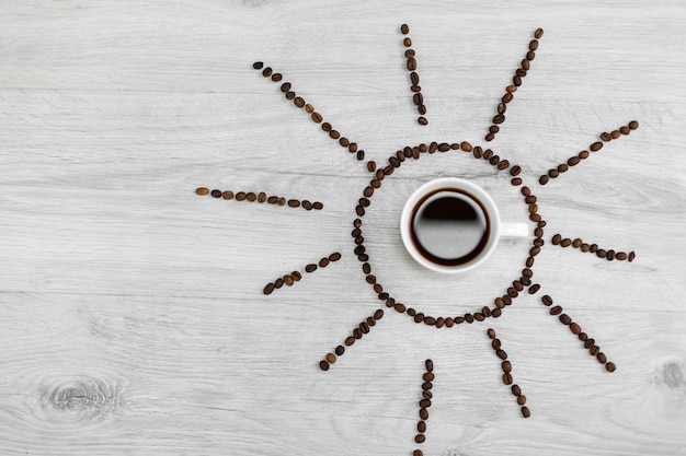 Grains de café pliés sous la forme du soleil sur un fond en bois