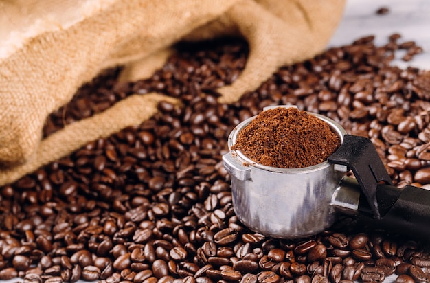 Grains de café et porte-filtre avec du café moulu torréfié