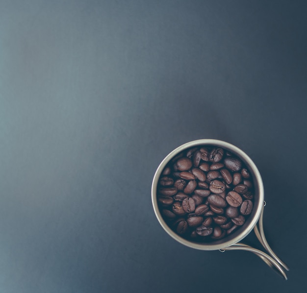 Grains de café et poudre moulue sur tableau noir. Vue de dessus avec espace copie