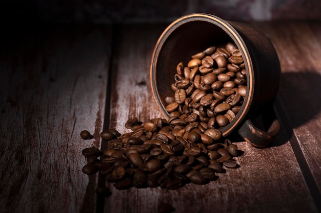 Photo grains de café renversés de la tasse sur la table dans la cuisine