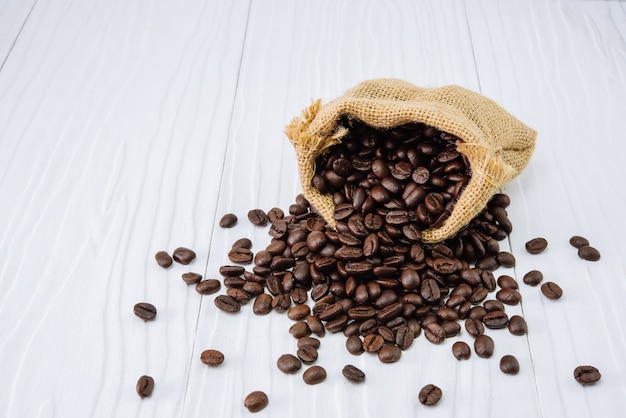 Grains de café avec sac sur bois