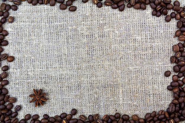Les grains de café se trouvent sur une toile de jute en toile de lin. Fond rétro