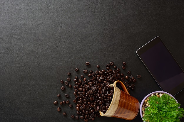 Des grains de café et des smartphones sont sur le bureau.