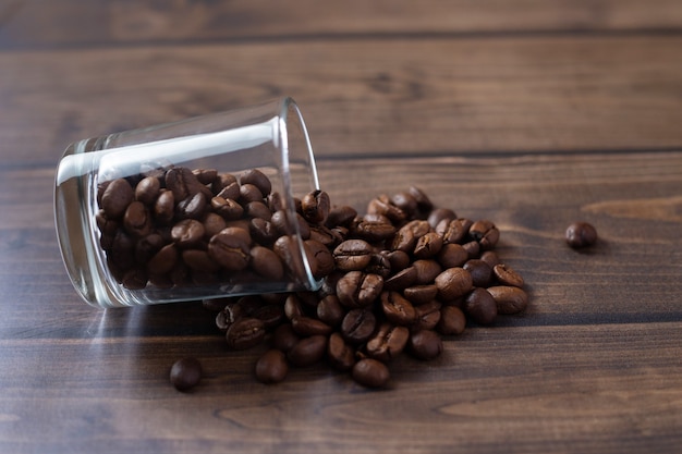 Grains de café sortant du récipient en verre