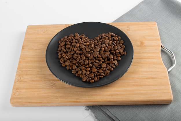 Grains de café sur soucoupe noire