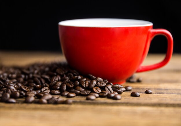 Grains de café sur une table avec tasse