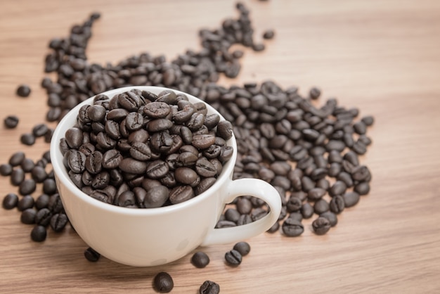 Grains de café et tasse sur fond en bois