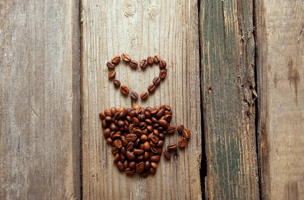 Photo grains de café et tasse sur fond en bois