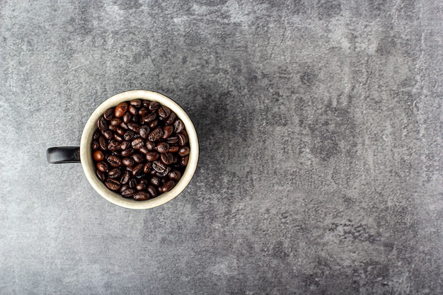 Photo grains de café et tasse noire blanche
