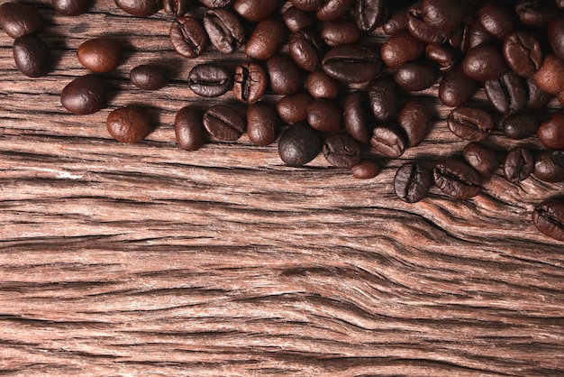 Grains de café torréfiés broyés sur un vieux fond en bois